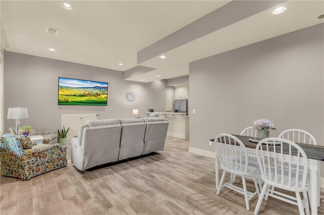 living room featuring light wood finished floors, baseboards, visible vents, and recessed lighting