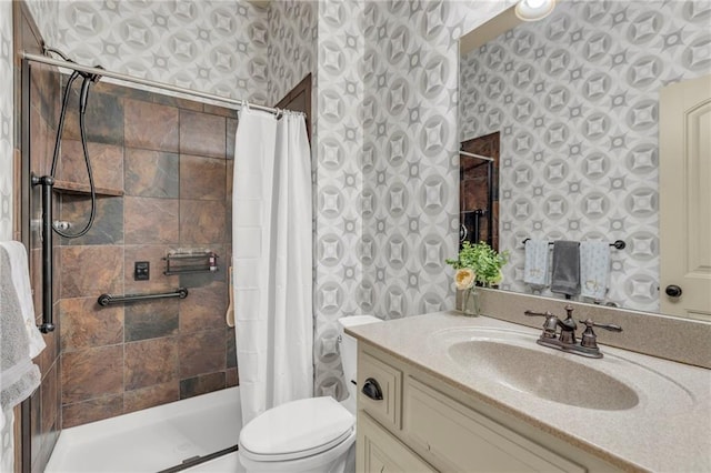 full bath with tiled shower, vanity, toilet, and wallpapered walls