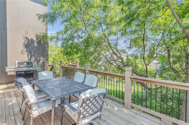 deck featuring outdoor dining space and a grill