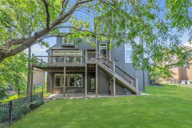 back of house featuring a deck, a yard, stairway, and fence private yard