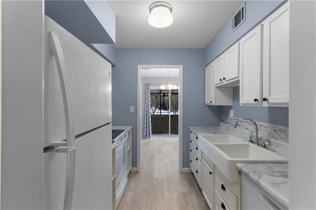 kitchen featuring light hardwood / wood-style flooring, sink, white cabinetry, light stone countertops, and white appliances