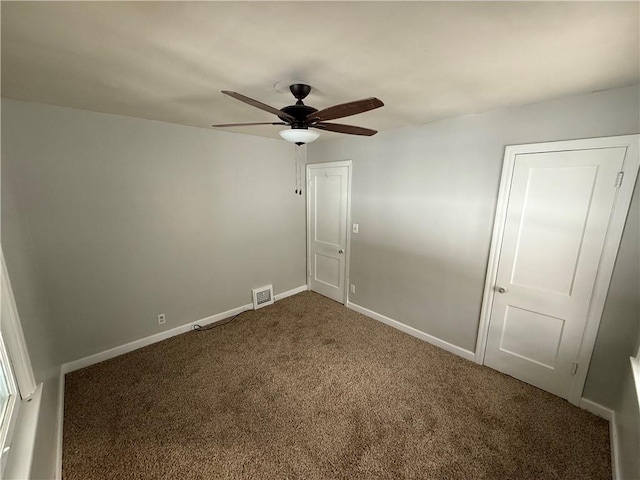 carpeted spare room featuring ceiling fan