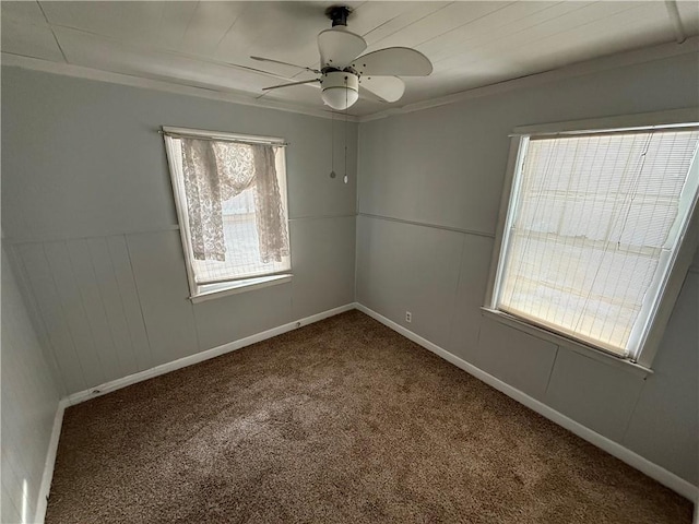 carpeted spare room featuring ceiling fan and crown molding