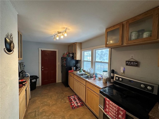 kitchen featuring black fridge, sink, and range with two ovens