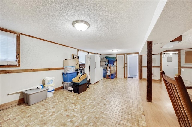 finished basement with a textured ceiling and light floors