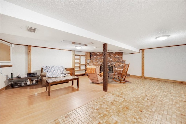 finished below grade area featuring a textured ceiling, wood finished floors, visible vents, and baseboards