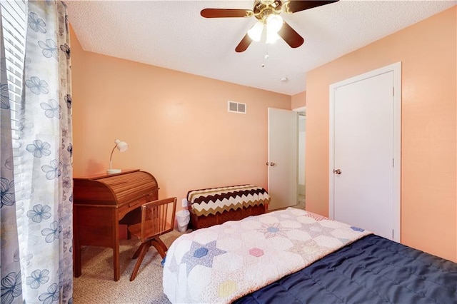 carpeted bedroom with visible vents, ceiling fan, and a textured ceiling