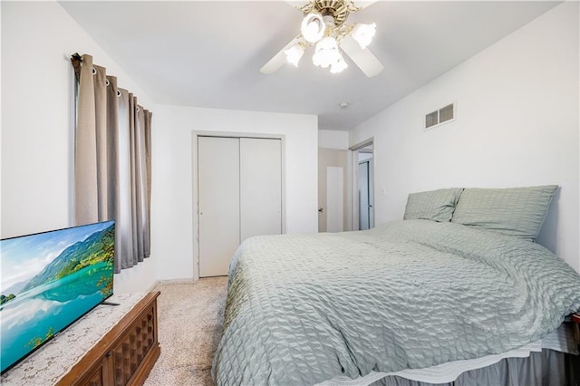 bedroom featuring light carpet, ceiling fan, visible vents, and a closet