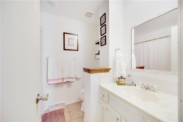 bathroom featuring tile patterned flooring, visible vents, vanity, and toilet