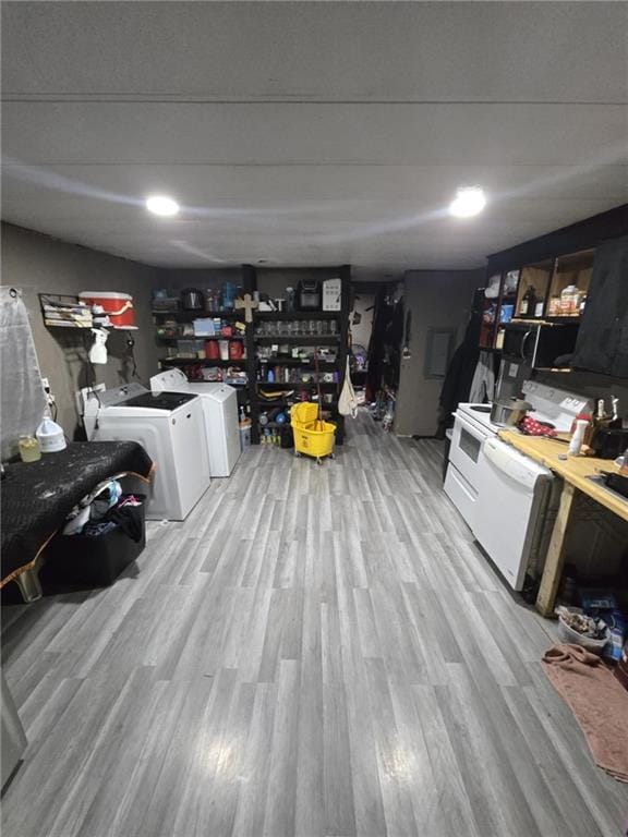 basement with light hardwood / wood-style floors and independent washer and dryer