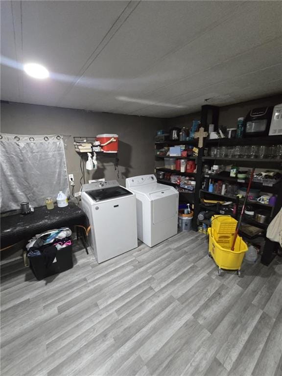 laundry area with independent washer and dryer and light wood-type flooring