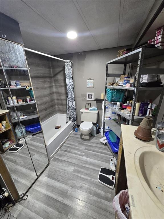 full bathroom with toilet, sink, shower / bath combination with curtain, and hardwood / wood-style floors