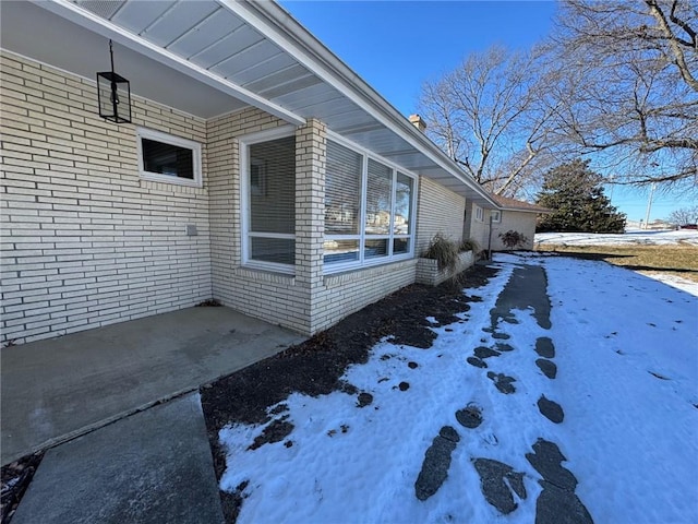 view of snowy exterior with a patio area