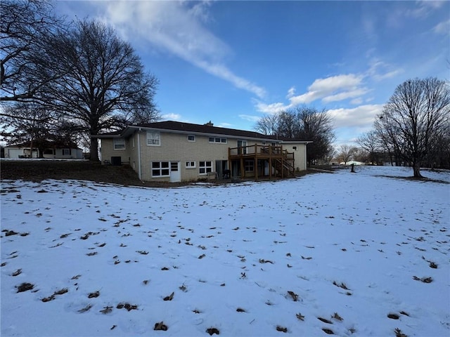 snow covered property with a deck