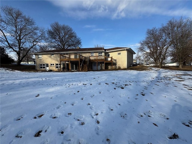 snow covered house with a deck