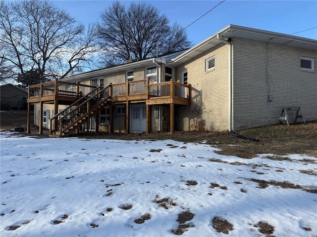 snow covered property with a deck