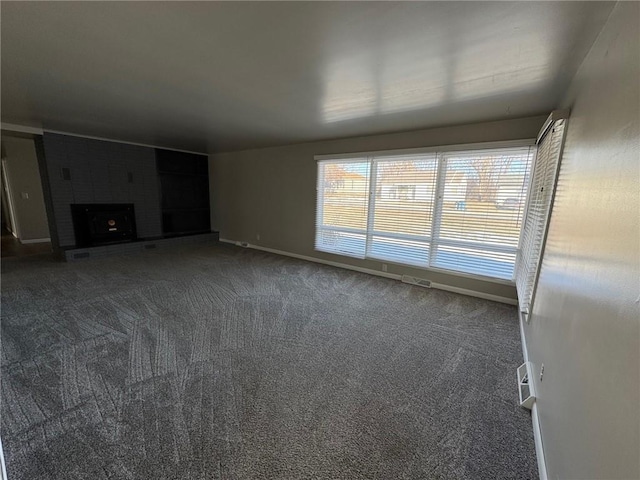 unfurnished living room featuring dark carpet and a fireplace