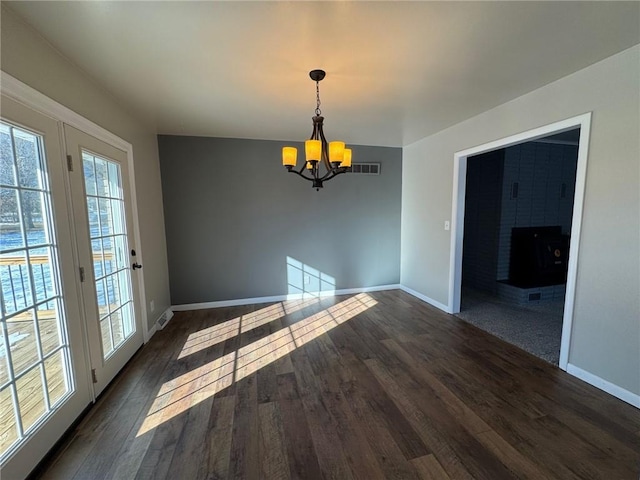 unfurnished dining area with dark hardwood / wood-style floors and a chandelier