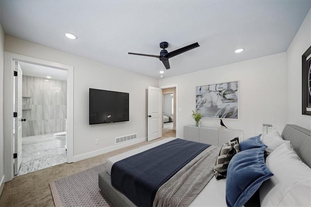 bedroom with ceiling fan, light colored carpet, and ensuite bathroom