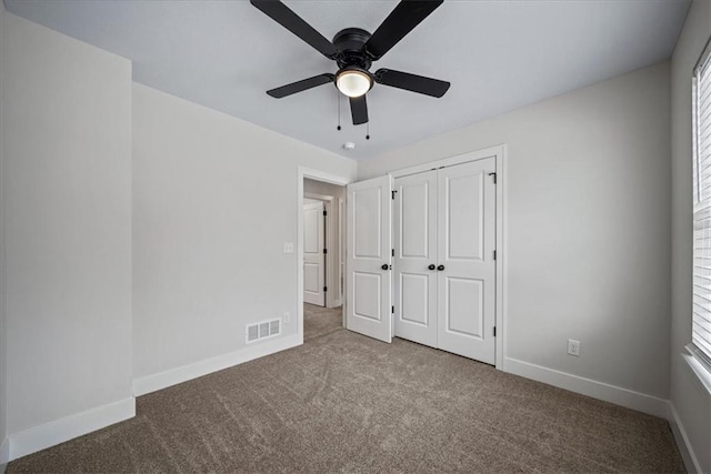 unfurnished bedroom with ceiling fan, light colored carpet, a closet, and multiple windows