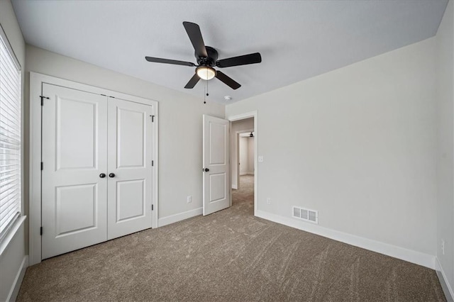 unfurnished bedroom featuring ceiling fan, carpet, and a closet