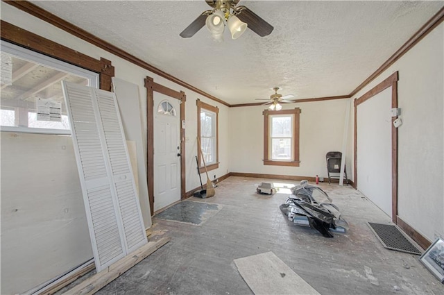 entryway with visible vents, baseboards, a textured ceiling, and ornamental molding