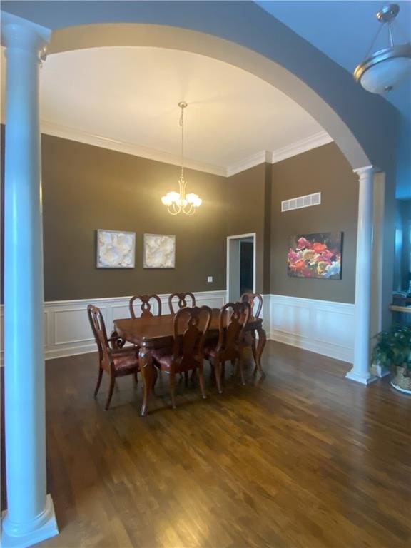 dining room featuring dark hardwood / wood-style floors, ornamental molding, and an inviting chandelier