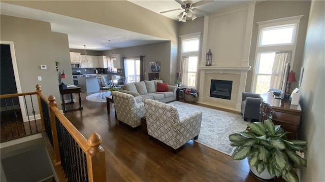 living room with ceiling fan and dark wood-type flooring