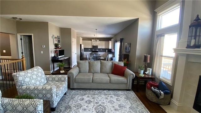 living room with hardwood / wood-style floors, an inviting chandelier, and a fireplace