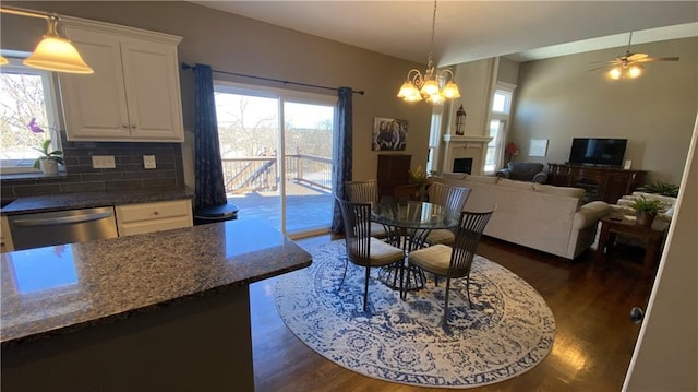 dining space featuring plenty of natural light, dark hardwood / wood-style flooring, and ceiling fan with notable chandelier