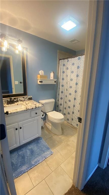 bathroom with toilet, tile patterned flooring, vanity, and curtained shower