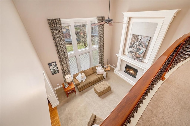 living area featuring ceiling fan and light carpet