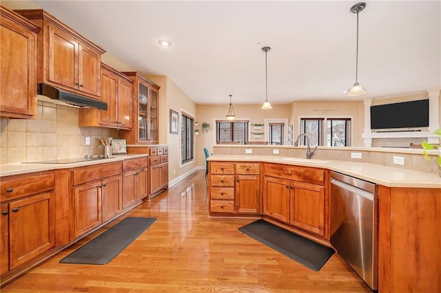 kitchen with sink, hanging light fixtures, light wood-type flooring, stainless steel dishwasher, and decorative backsplash