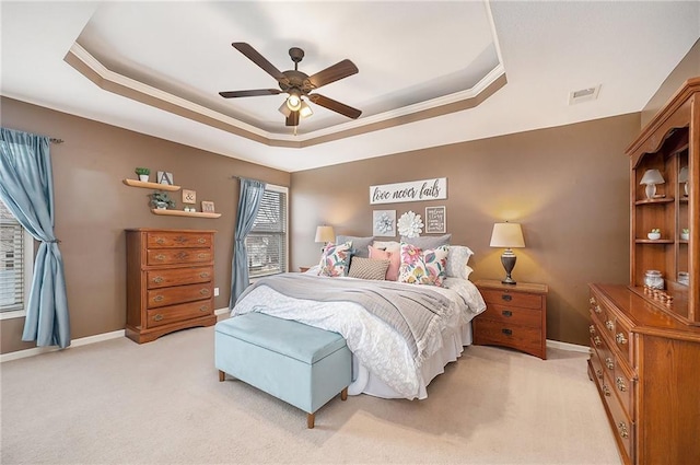 carpeted bedroom featuring crown molding, a raised ceiling, and ceiling fan