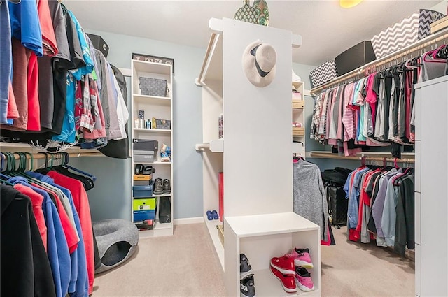 walk in closet featuring light colored carpet