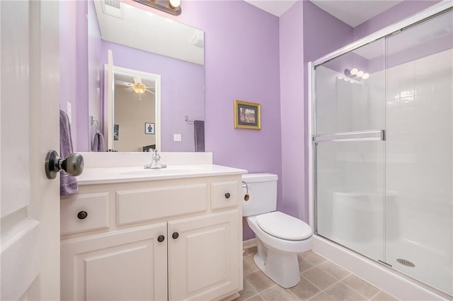 bathroom featuring a shower with door, vanity, tile patterned flooring, and toilet