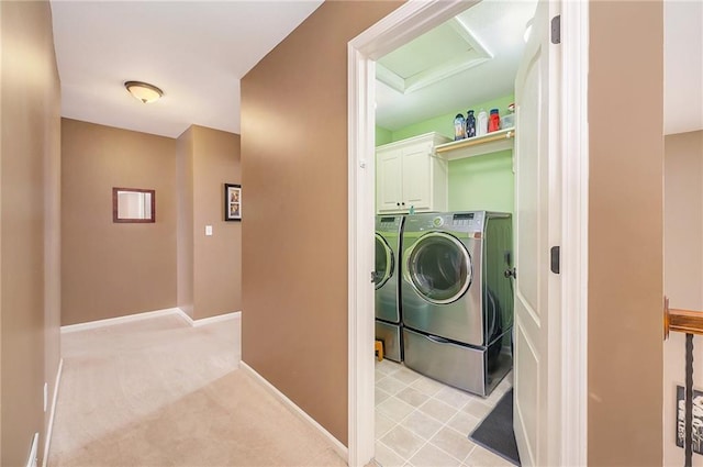 washroom featuring cabinets, washer and clothes dryer, and light colored carpet