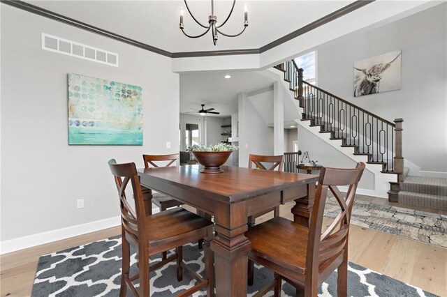 dining room featuring hardwood / wood-style flooring, crown molding, and an inviting chandelier