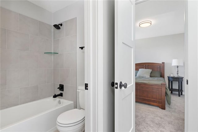 bathroom with tiled shower / bath combo and toilet