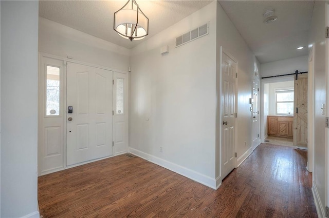 foyer with dark hardwood / wood-style flooring and a barn door