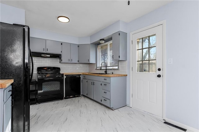 kitchen with black appliances, sink, wood counters, and gray cabinetry