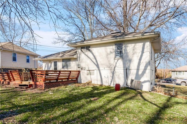 rear view of property with a wooden deck and a yard