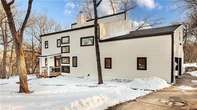 snow covered rear of property with a garage