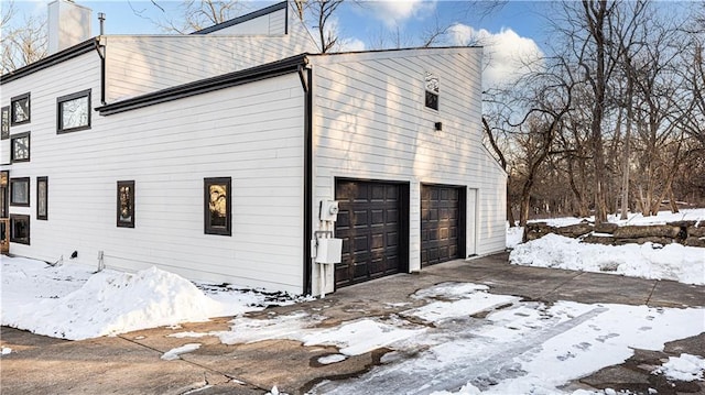 view of snow covered exterior featuring a garage