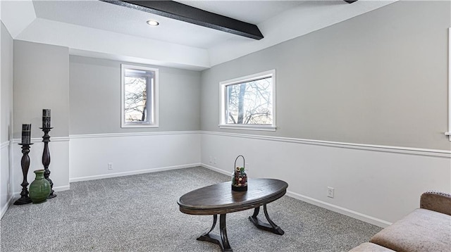 living area featuring carpet floors and beamed ceiling