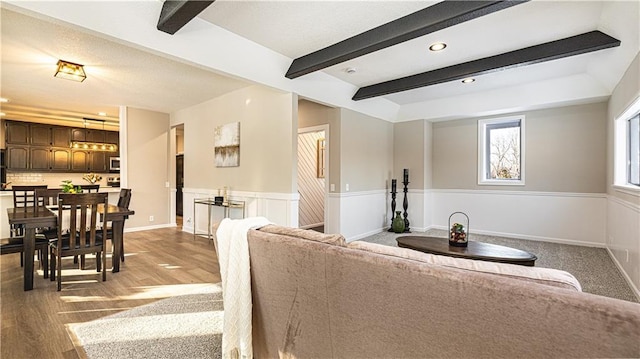 living room featuring beam ceiling and hardwood / wood-style flooring