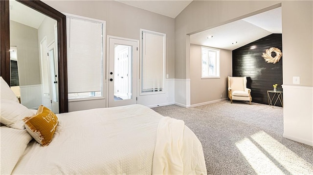 carpeted bedroom with wooden walls and vaulted ceiling