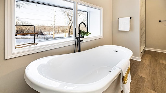 bathroom with hardwood / wood-style flooring and a washtub