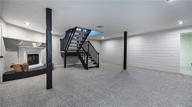 basement featuring a textured ceiling and carpet flooring