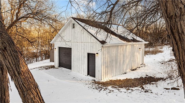 snow covered structure featuring a garage